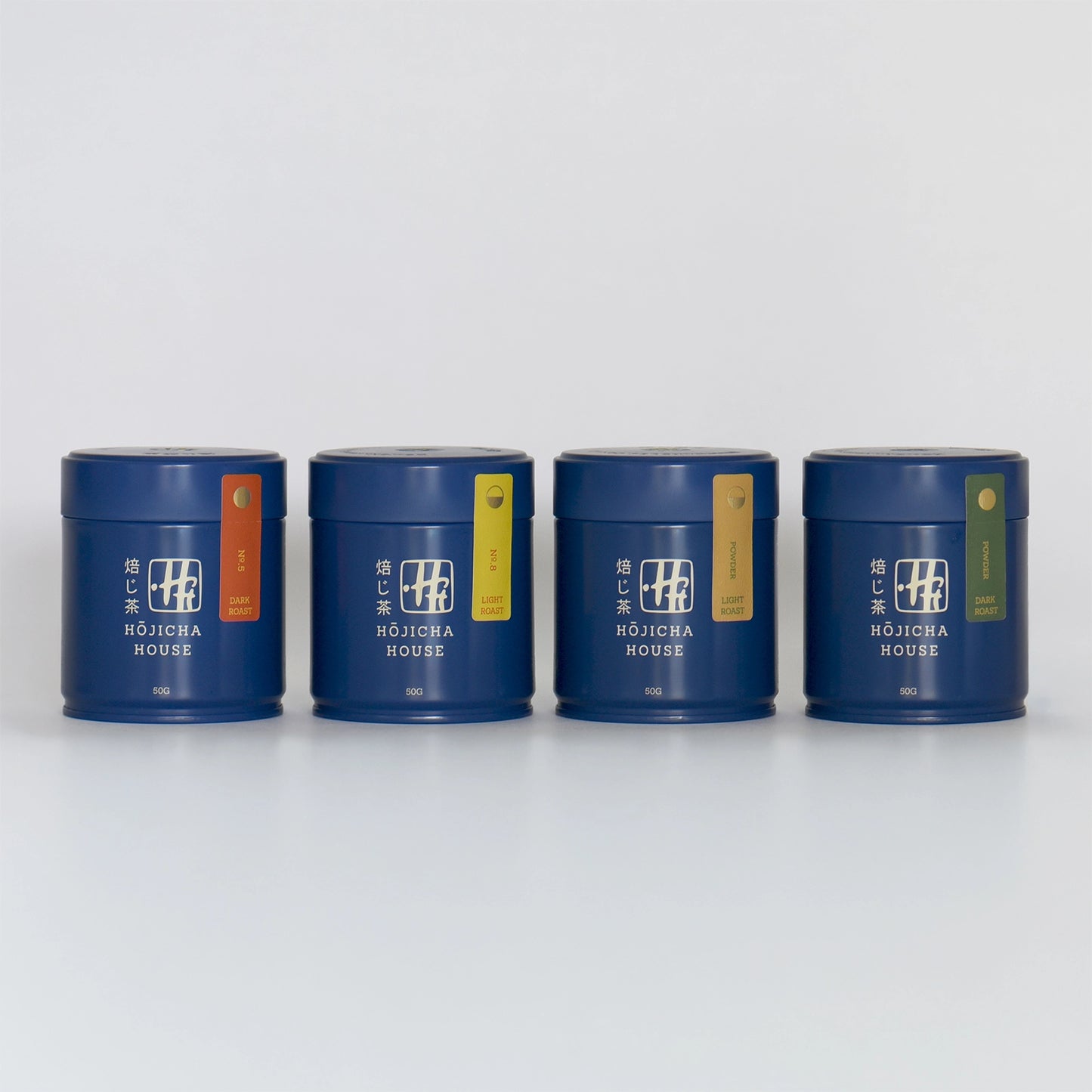 Four blue hojicha tea canisters with colorful labels on a white background
